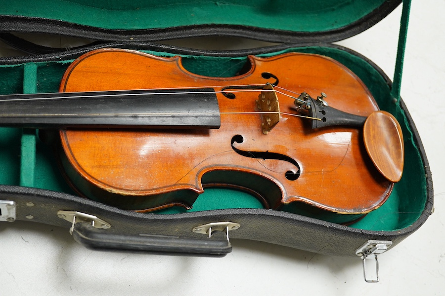 Four cased violins; an early 20th century violin, body 36cm, fitted with a microphone pick up taking a quarter inch jack plug, an early 20th century half size violin, body 32cm, and two student violins. Condition - poor